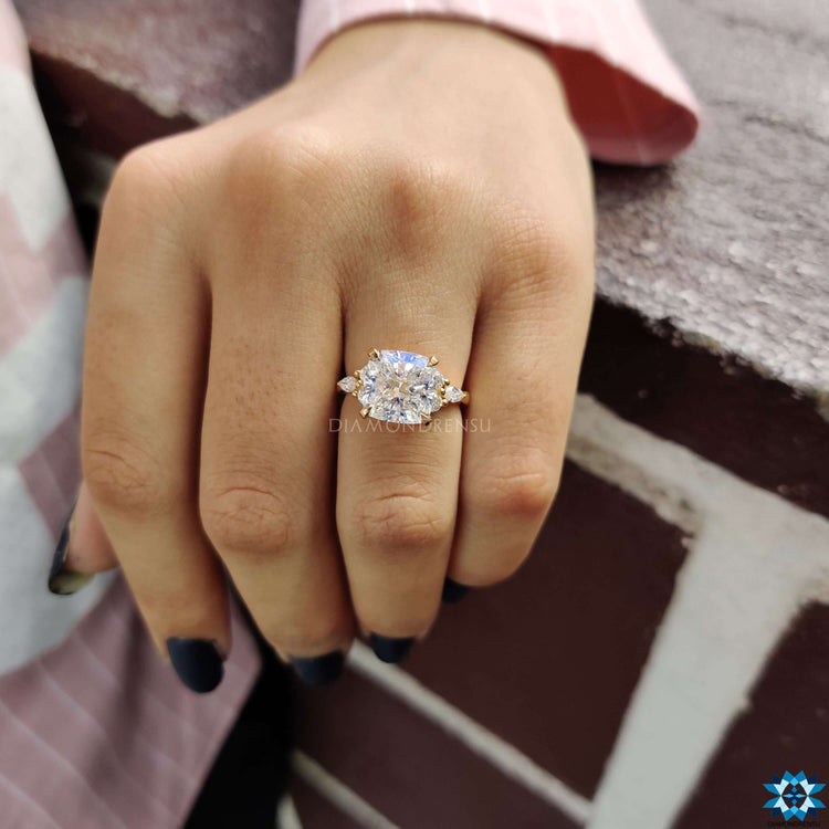 Moissanite engagement ring in a custom design featuring side stones and yellow gold finish.