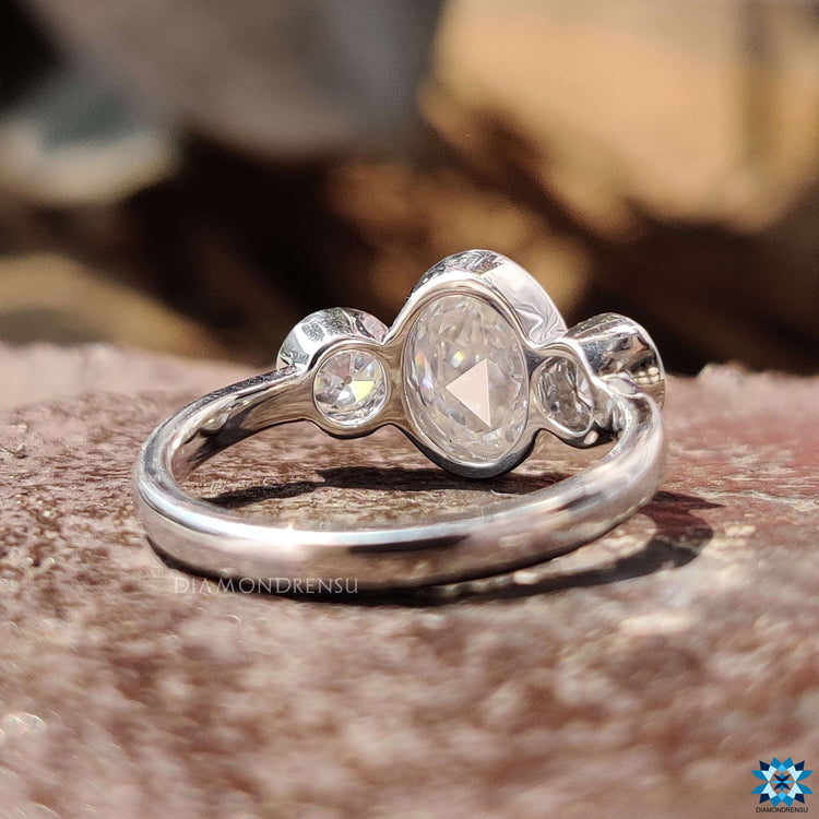 Bezel setting ring featuring three moissanite stones.