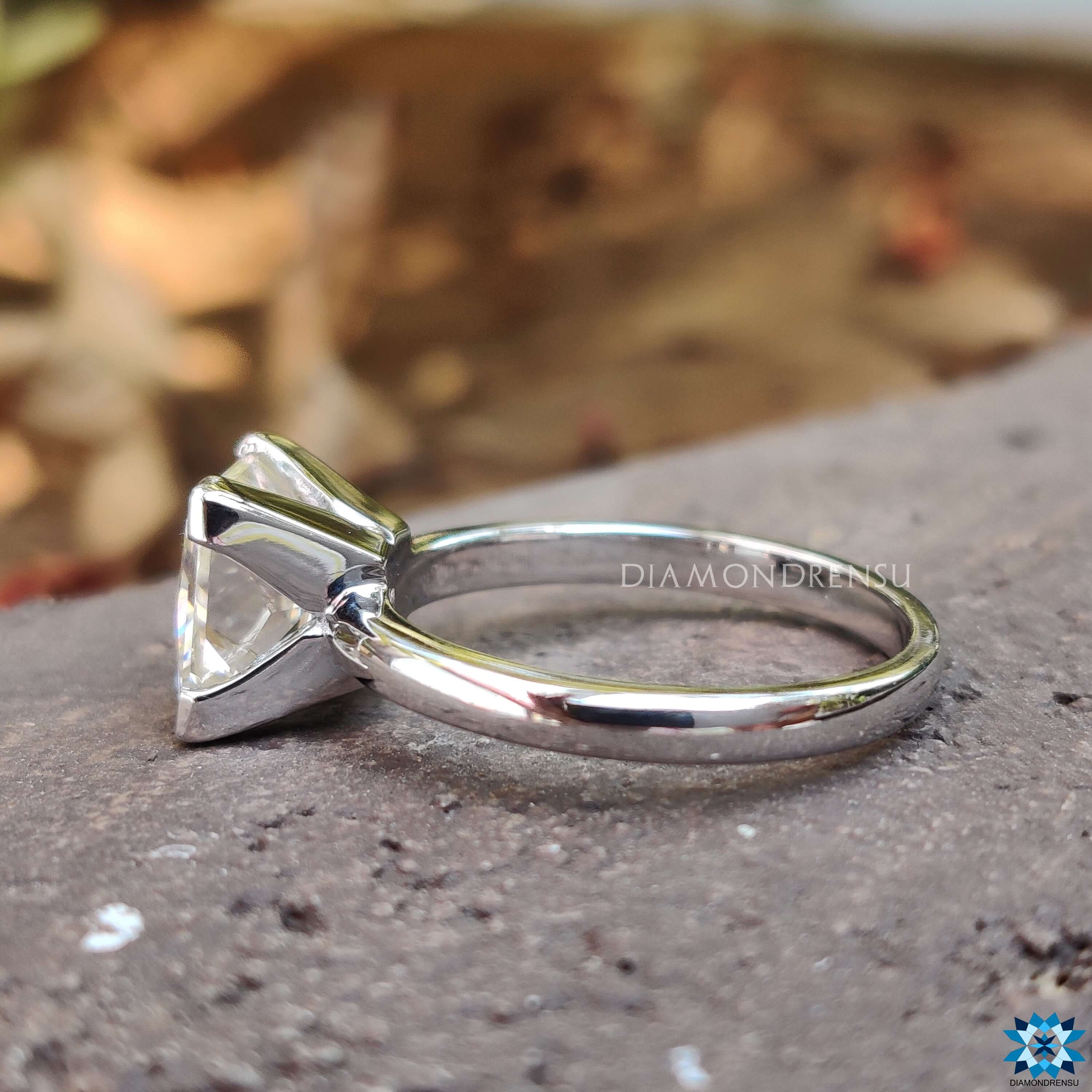 Solitaire moissanite ring with V-shaped prong setting.