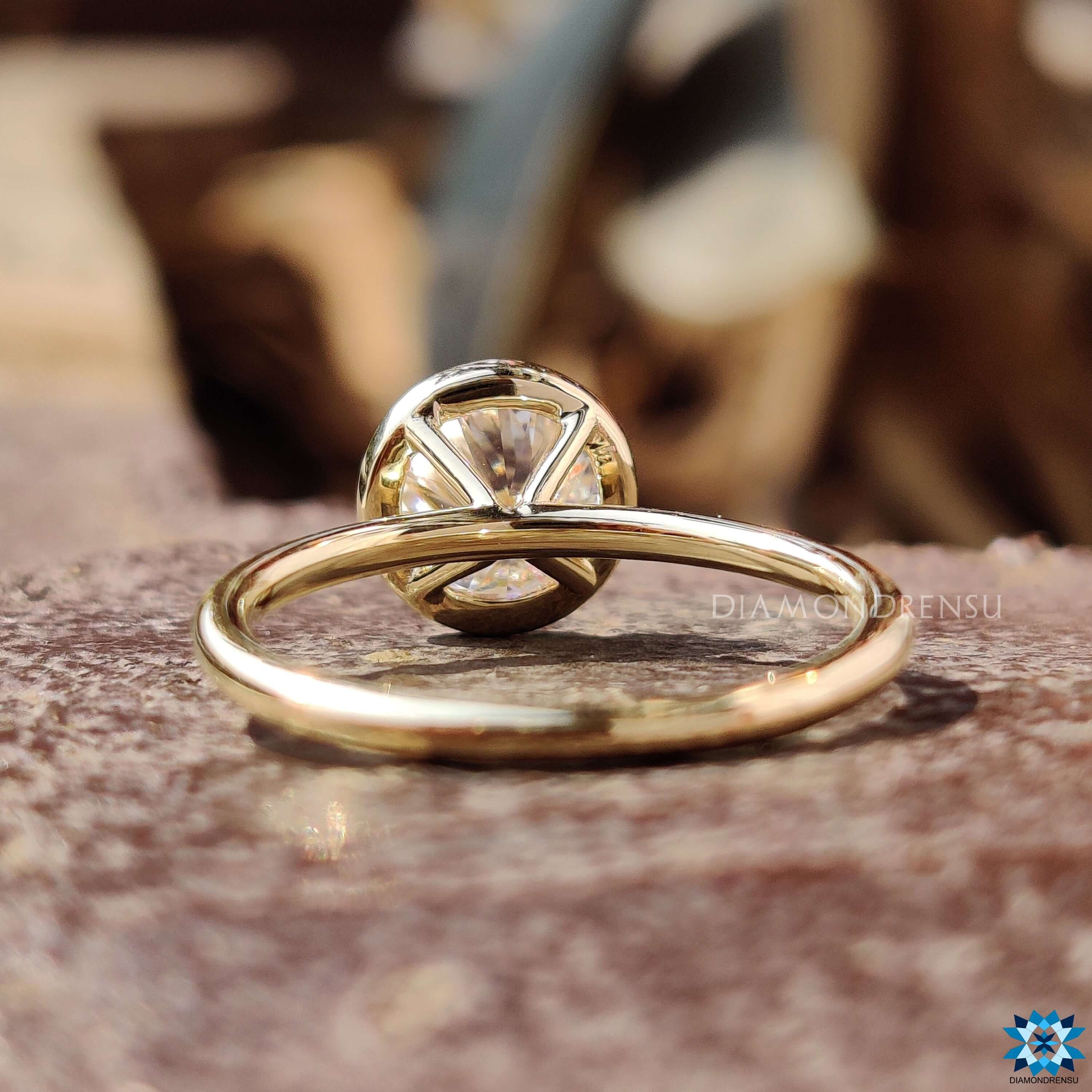 Custom round bezel set engagement ring handcrafted in gold.