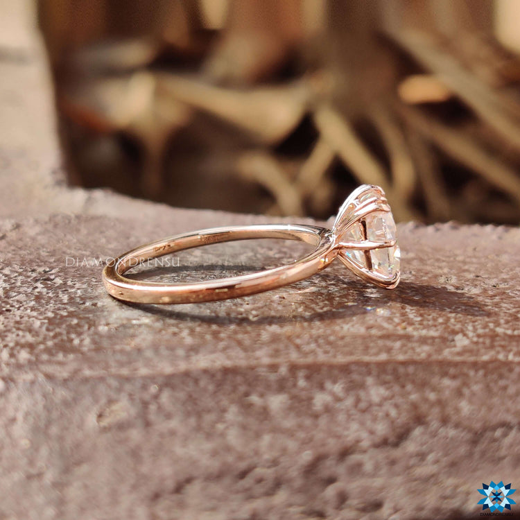 Rose gold engagement ring with double claw prongs.