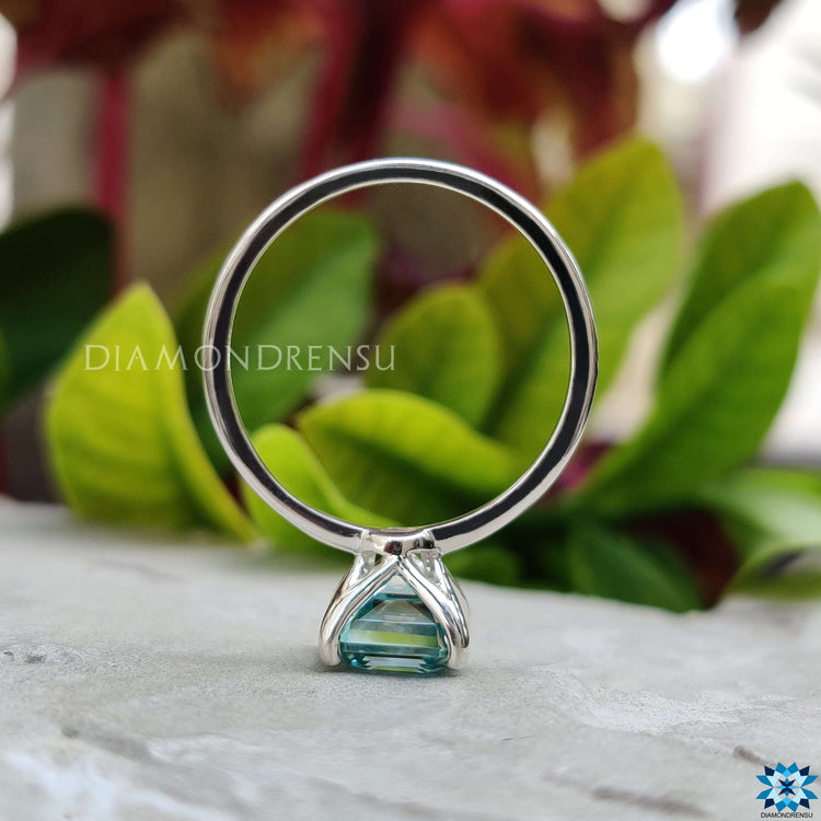 Asscher cut cyan moissanite ring with 4 prong mount.