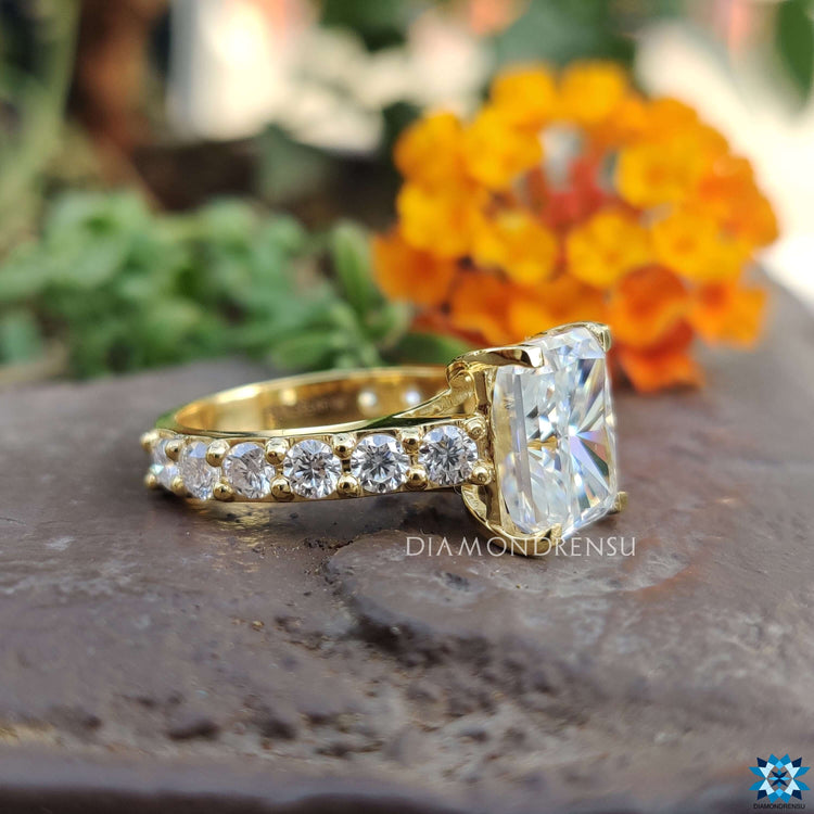 Handmade radiant moissanite ring with round cut accents.