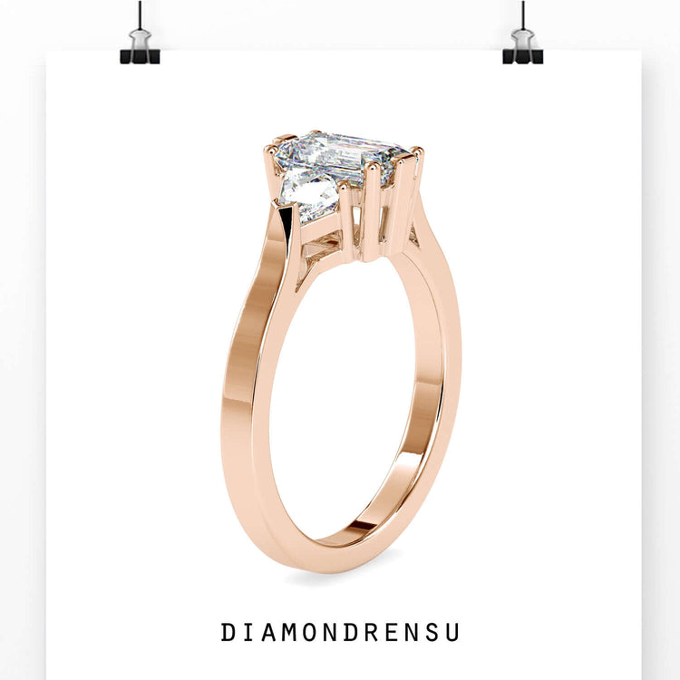 Custom design ring with prong set emerald and side diamonds.