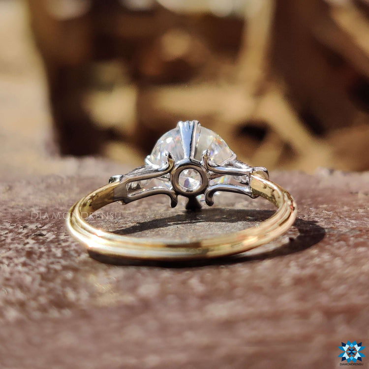 Vintage style round moissanite ring with fishtail prongs.