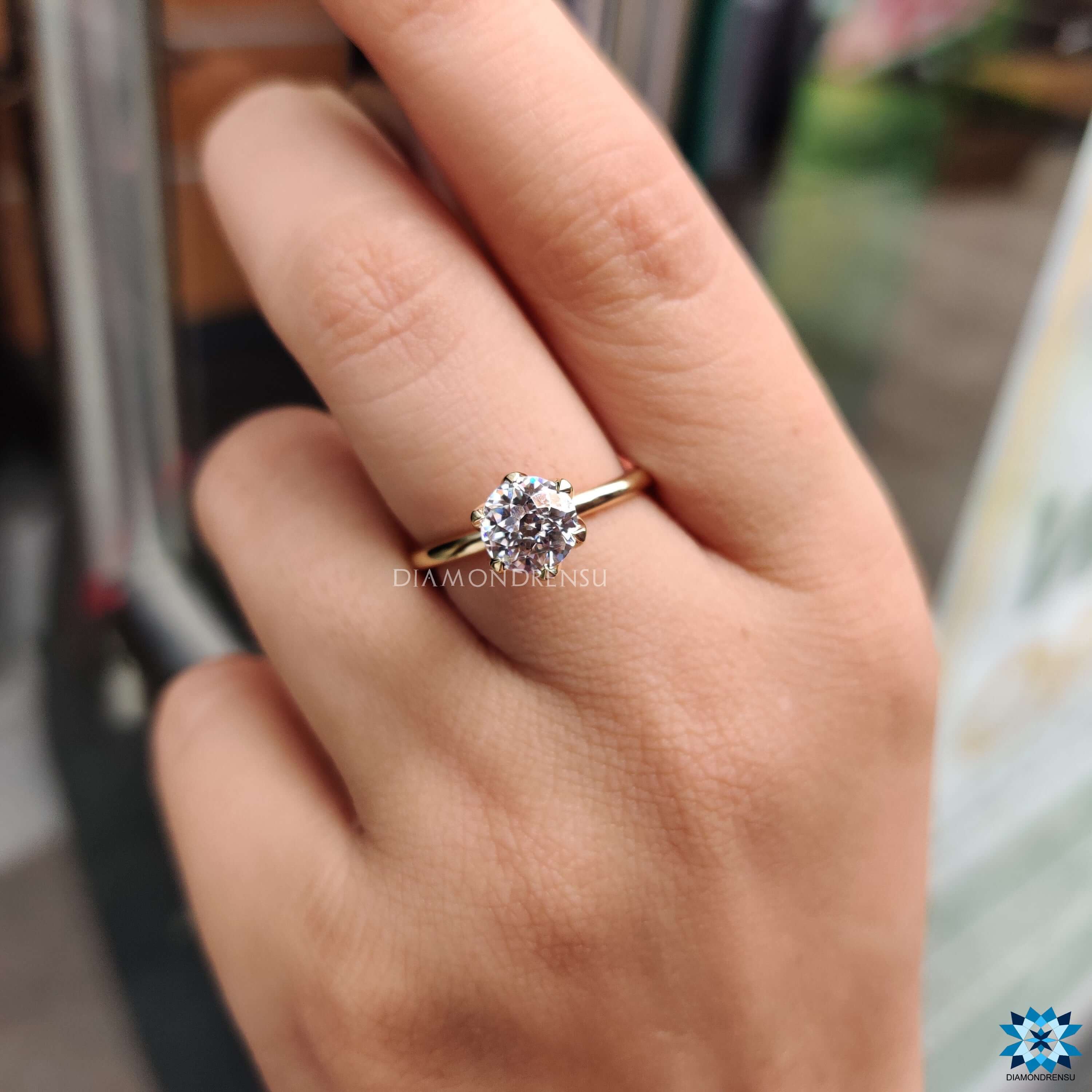 Simple solitaire moissanite ring in classic tulip setting.