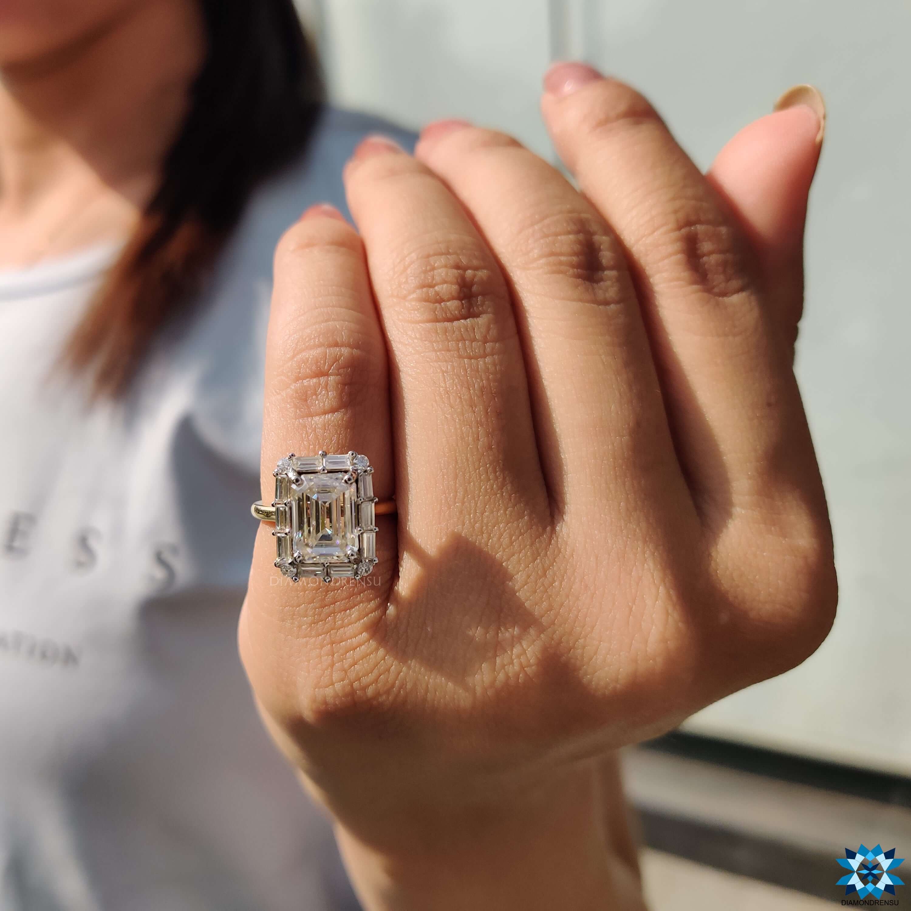 Baguette cut halo ring featuring emerald cut moissanite.