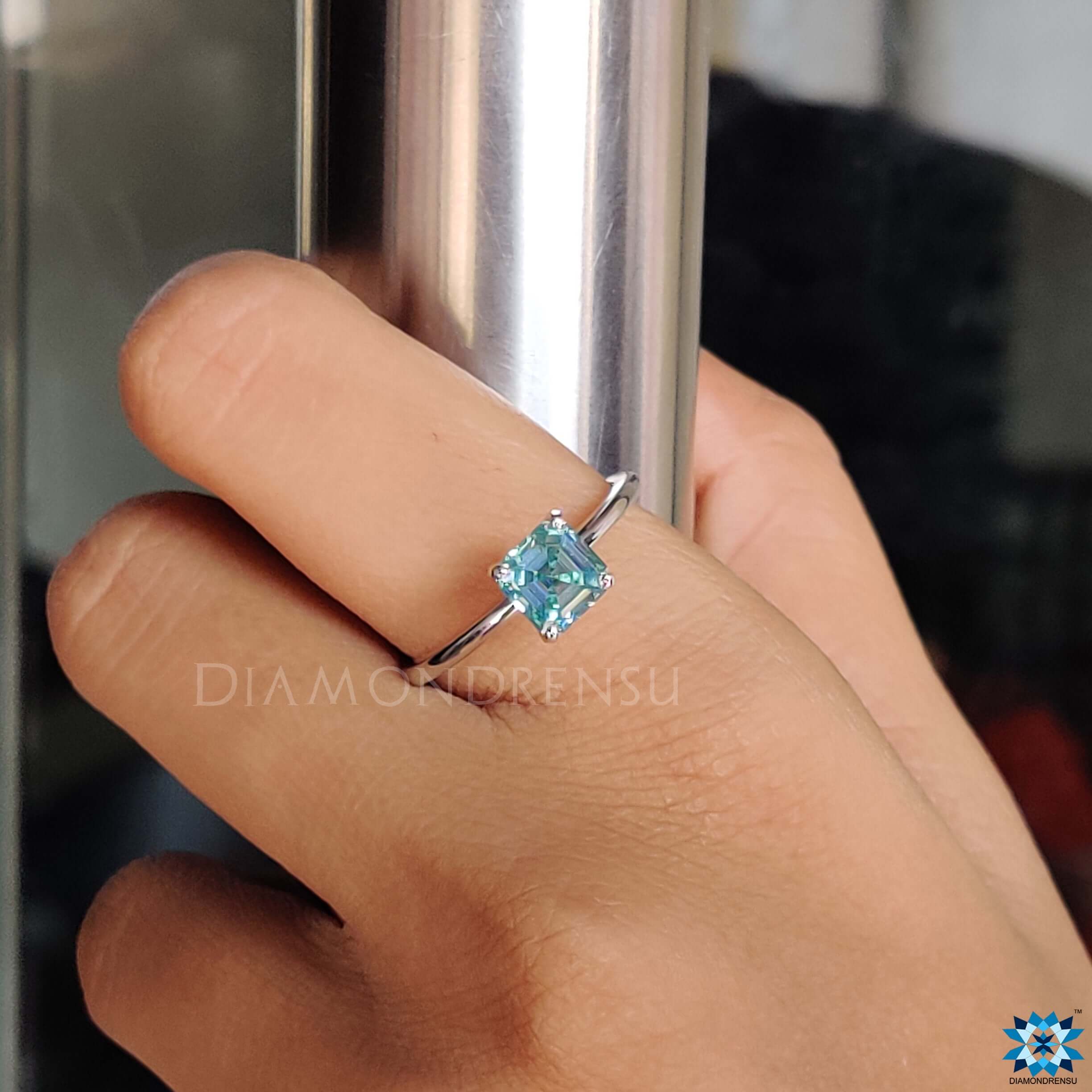 Handmade solitaire ring featuring an Asscher cut cyan blue moissanite.