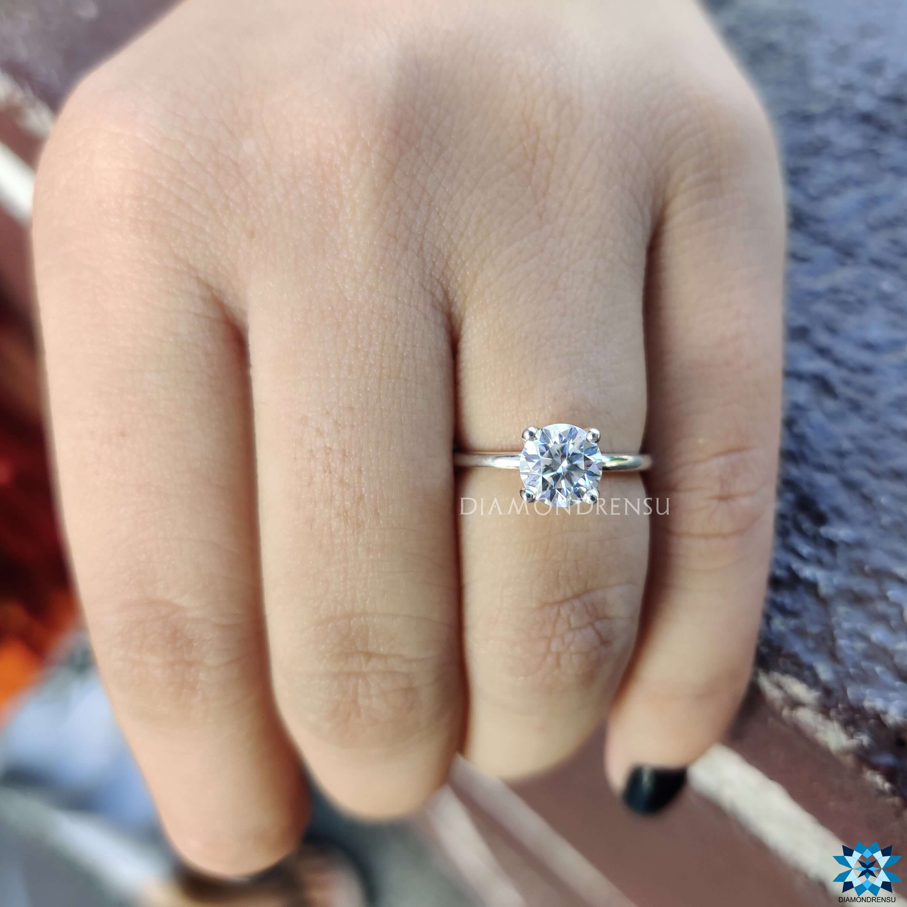 White gold solitaire ring with round moissanite center.