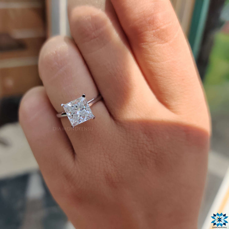 Cathedral setting engagement ring with a white gold band and princess cut moissanite.