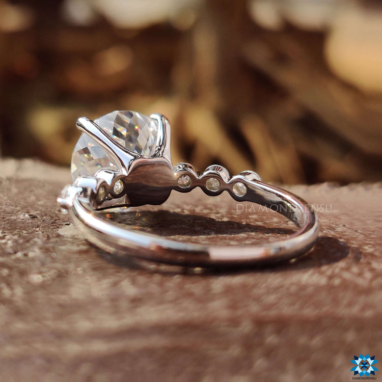 Four prong engagement ring with Portuguese cut stone and round moissanite accents.