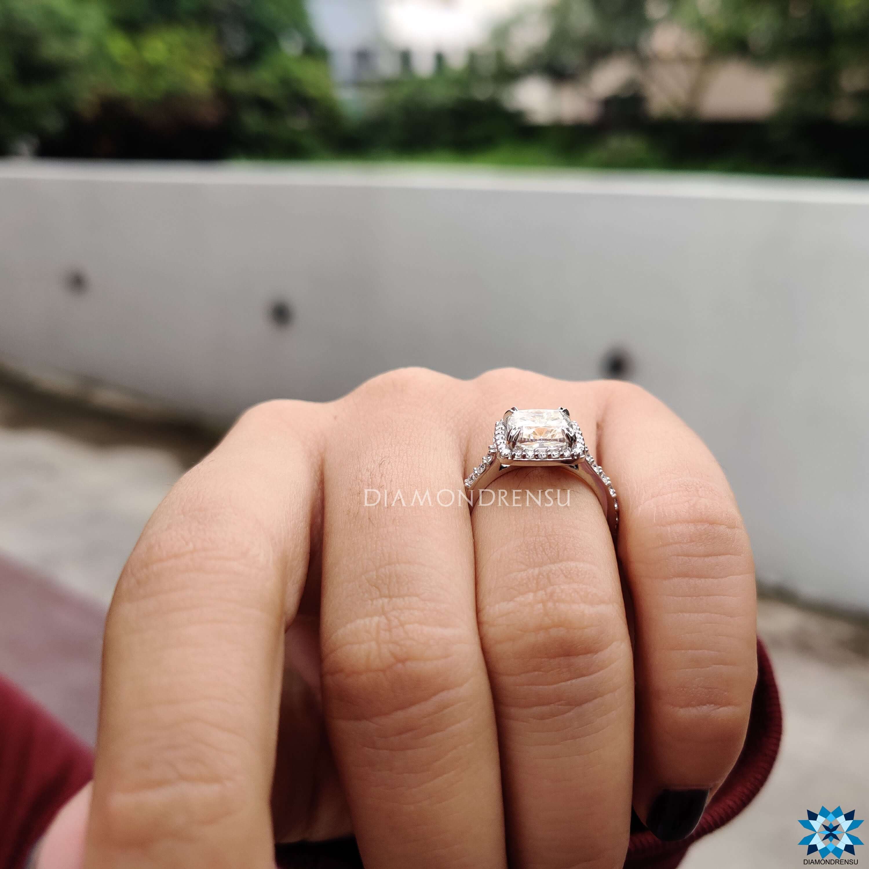 Pavé band moissanite ring with cushion cut center stone.