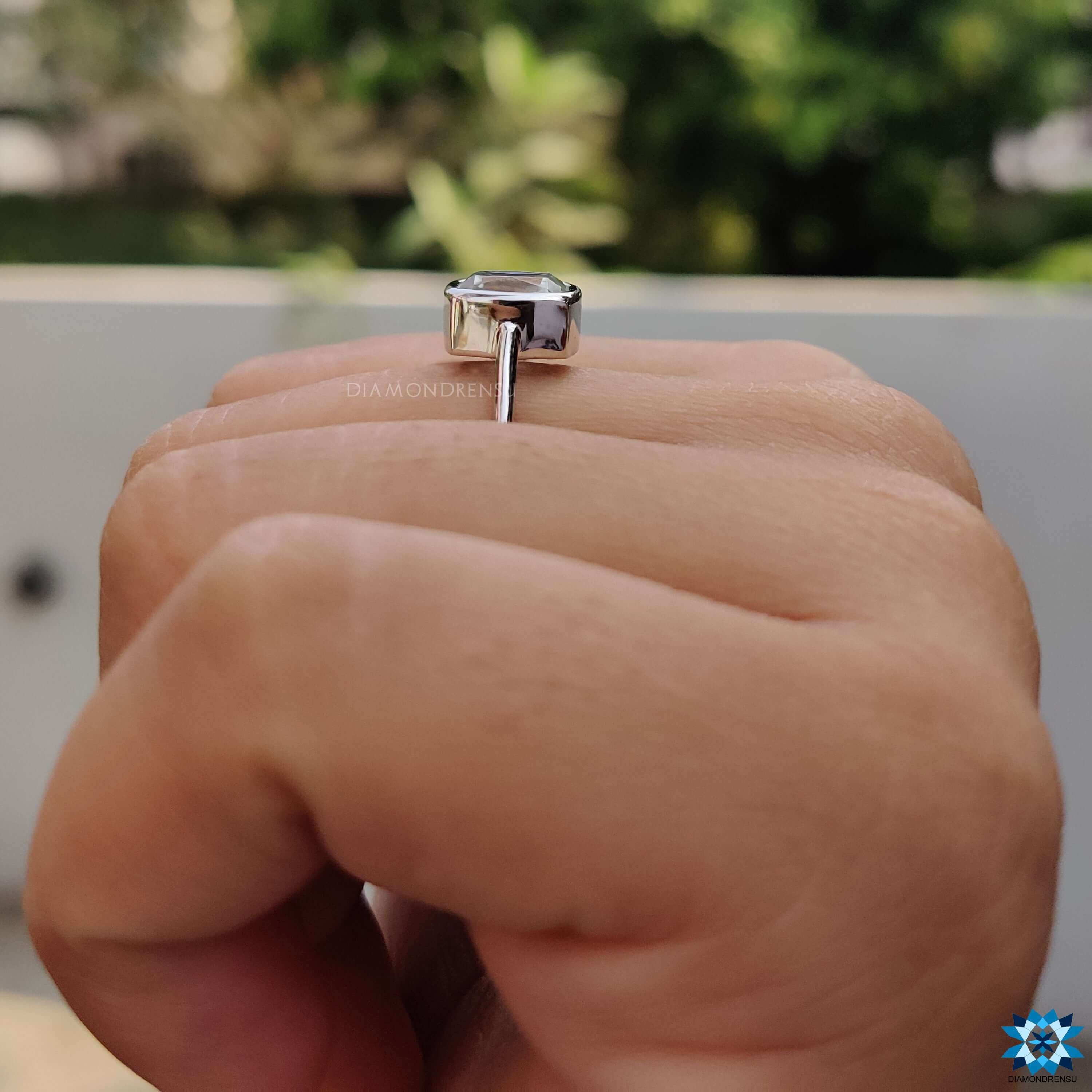 Moissanite engagement ring with cushion bezel setting.