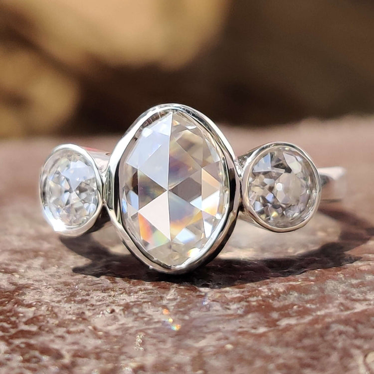 Three stone bezel set ring with oval rose cut center stone.