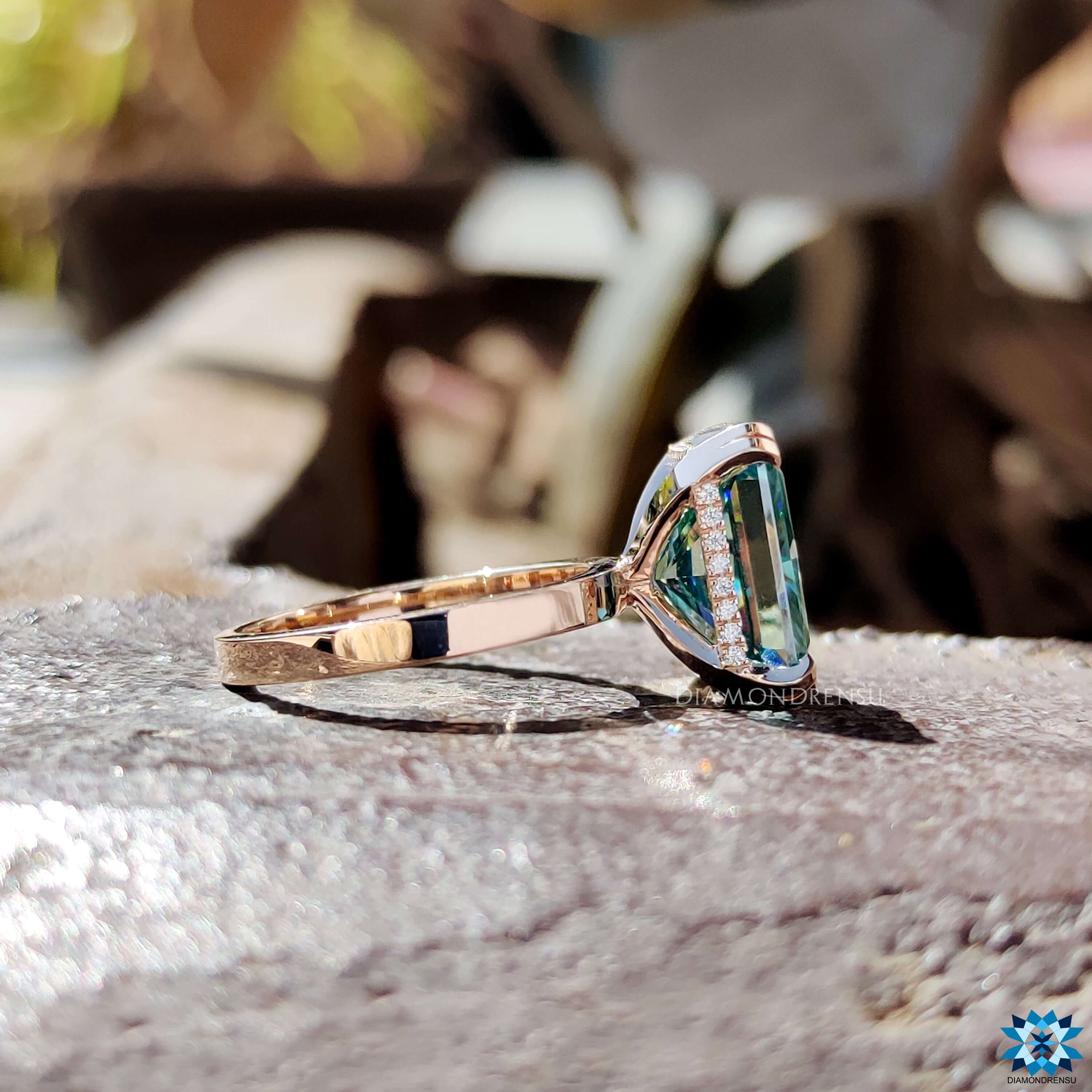 Cyan Blue Radiant cut moissanite ring with round accents.