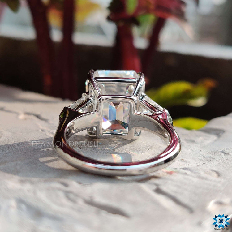 White gold ring with emerald cut and tapered side stones.