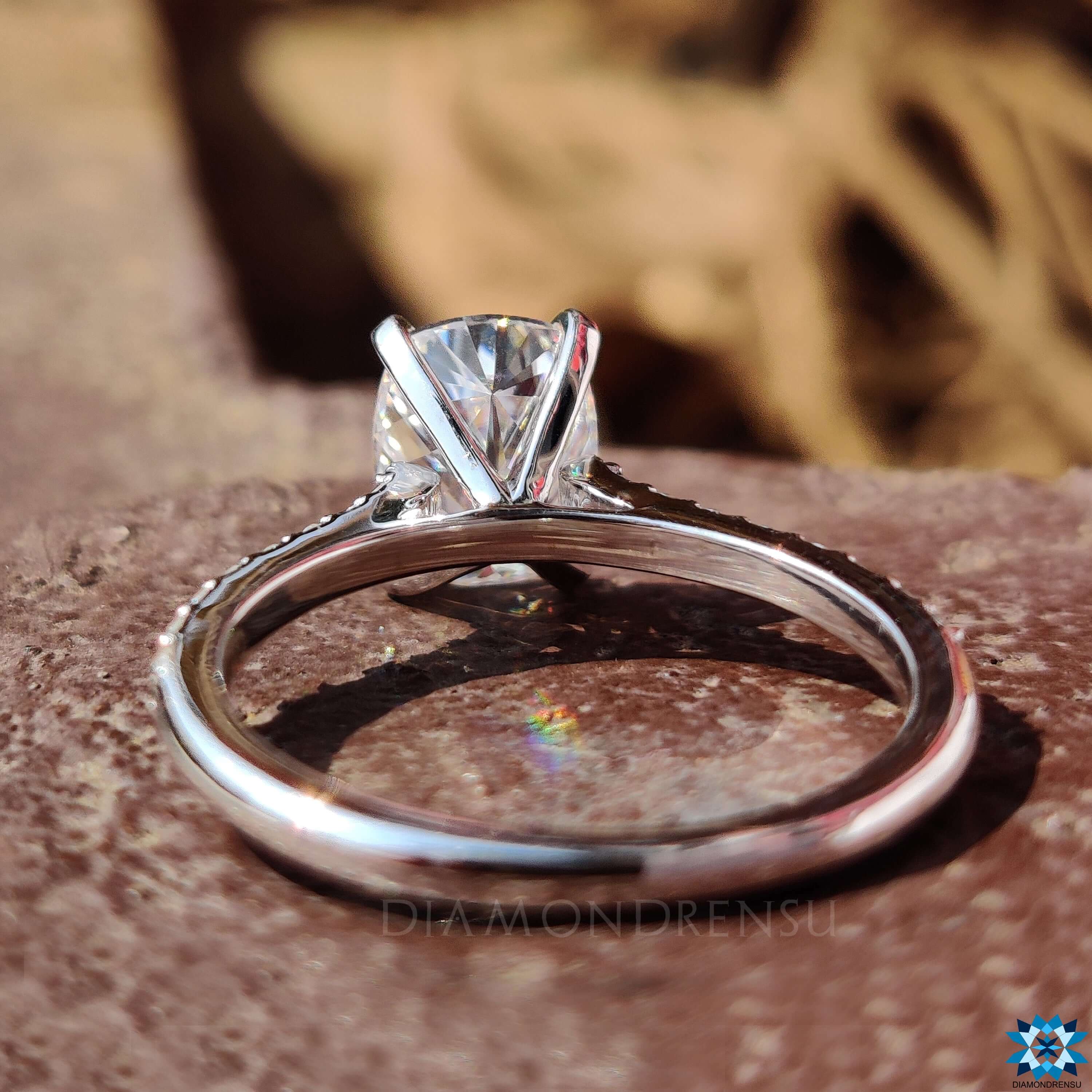 White gold moissanite ring with 4 tab prong and round pave setting.