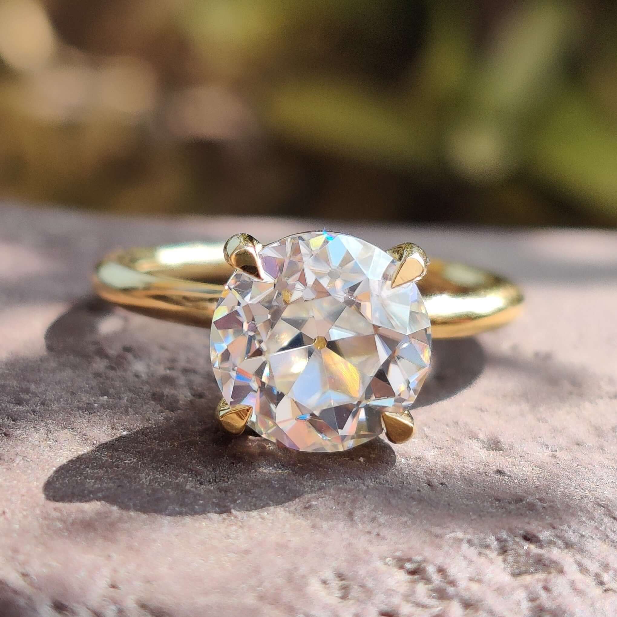 Round solitaire moissanite engagement ring in yellow gold.