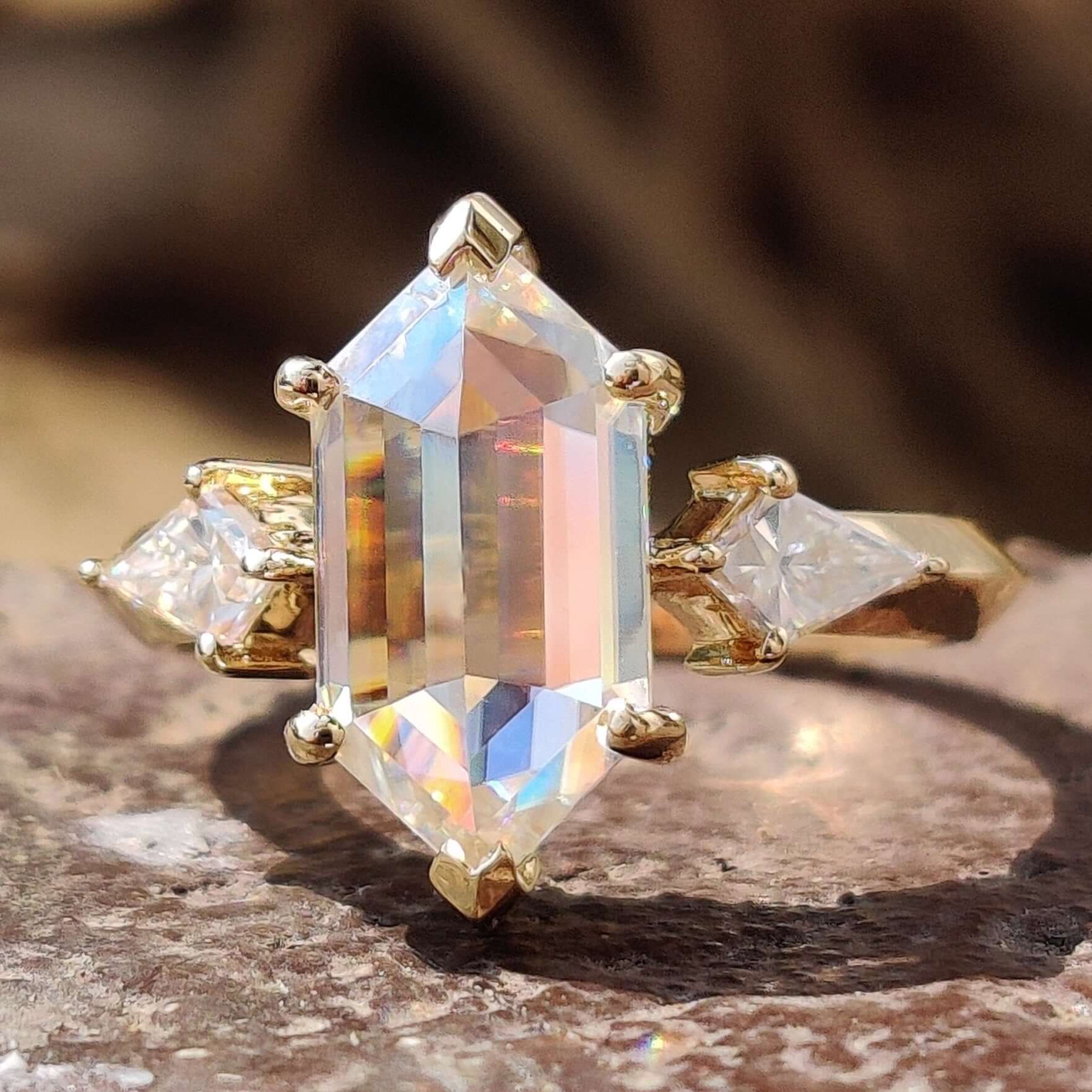Three stone moissanite ring with hexagon center.