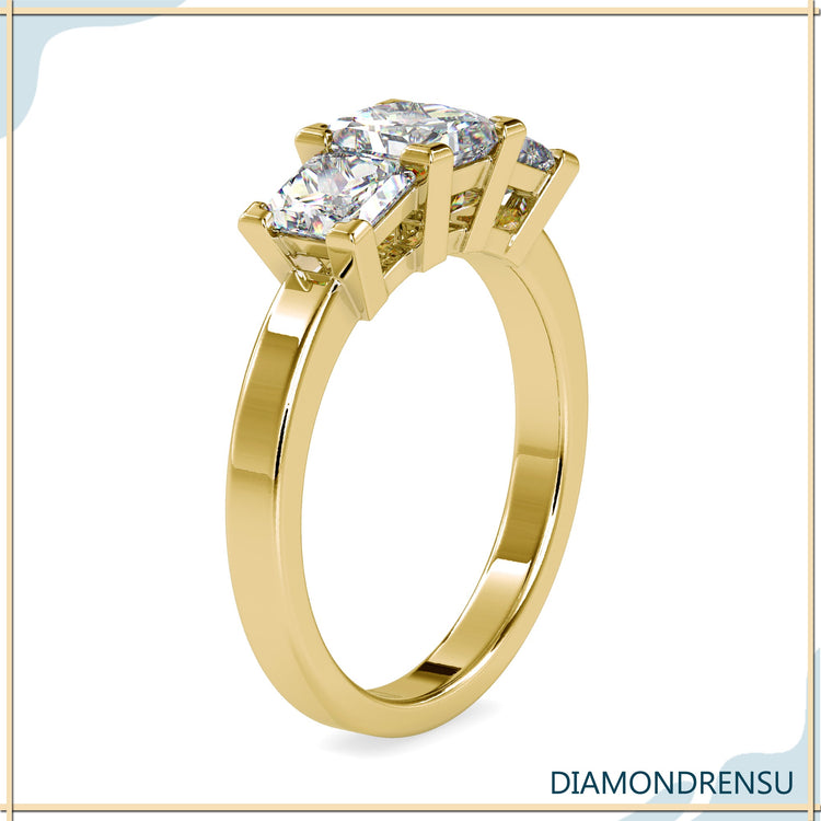 Custom design ring with three stone arrangement in yellow gold.