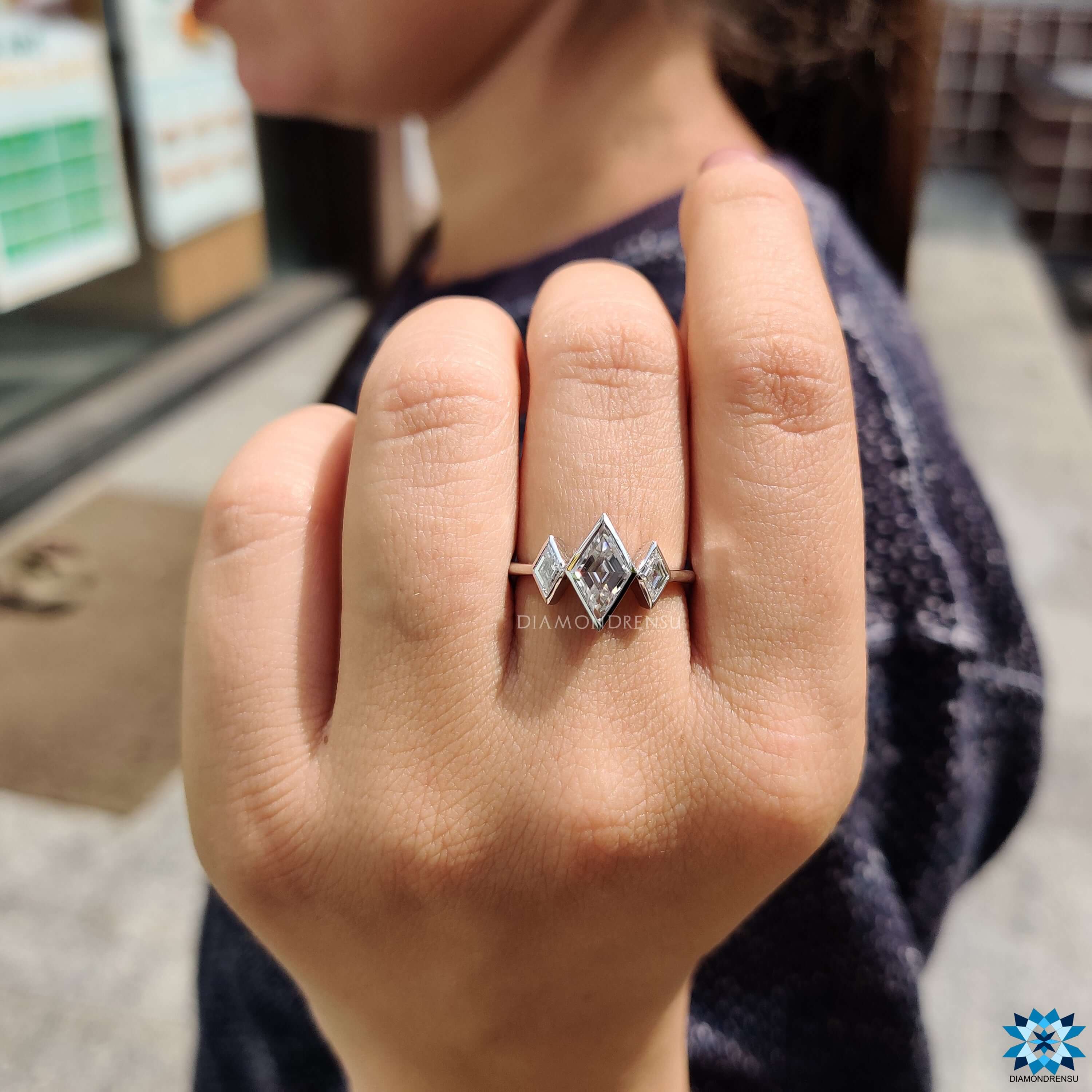 Three stone engagement ring with lozenge cut moissanite.