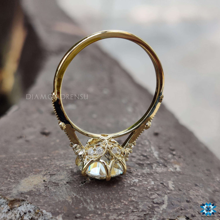 Muse setting engagement ring with round moissanite stone.