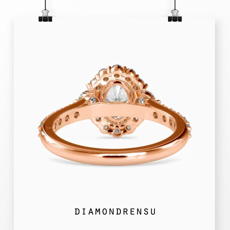 Simple diamond ring with oval centre and pave cluster halo.