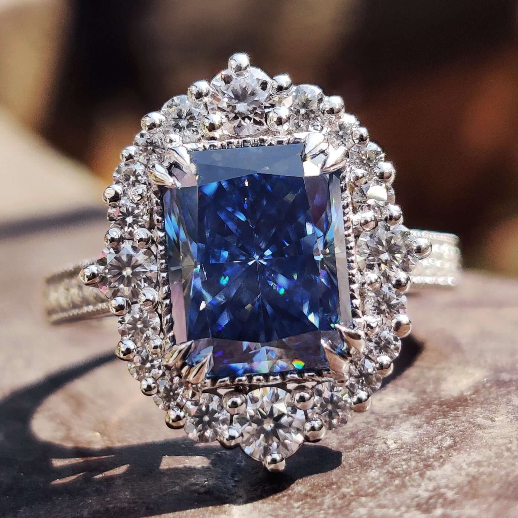 Radiant cut blue moissanite ring with milgrain detailing.