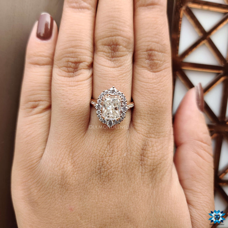 Radiant moissanite ring with round halo and rose gold band.