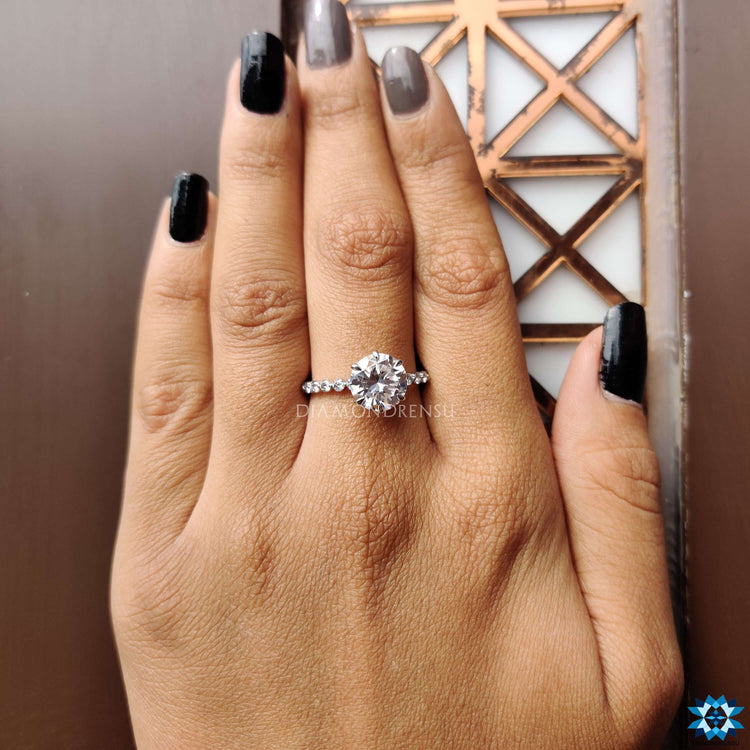 Moissanite engagement ring crafted in white gold with shared prong band.