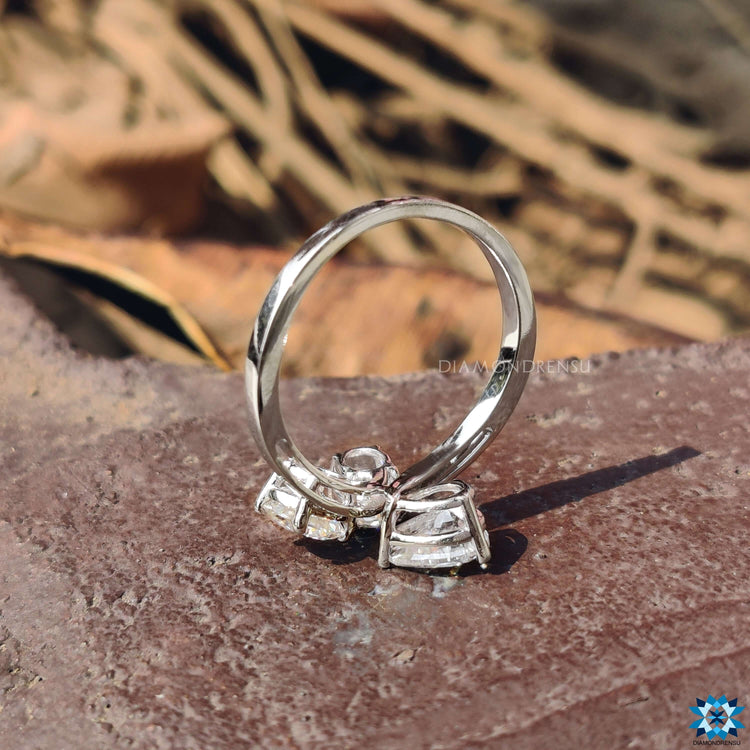 Moissanite engagement ring with oval, round, and pear cuts.