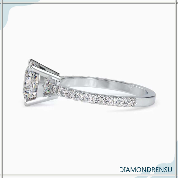 UK engagement ring with cushion cut and round side stones.