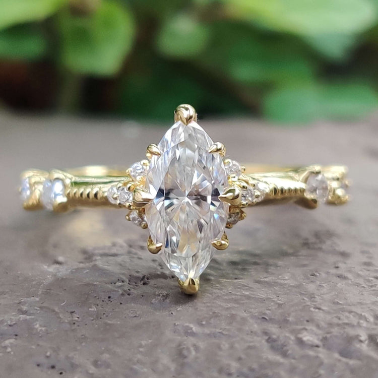 Marquise moissanite engagement ring with round side stones.