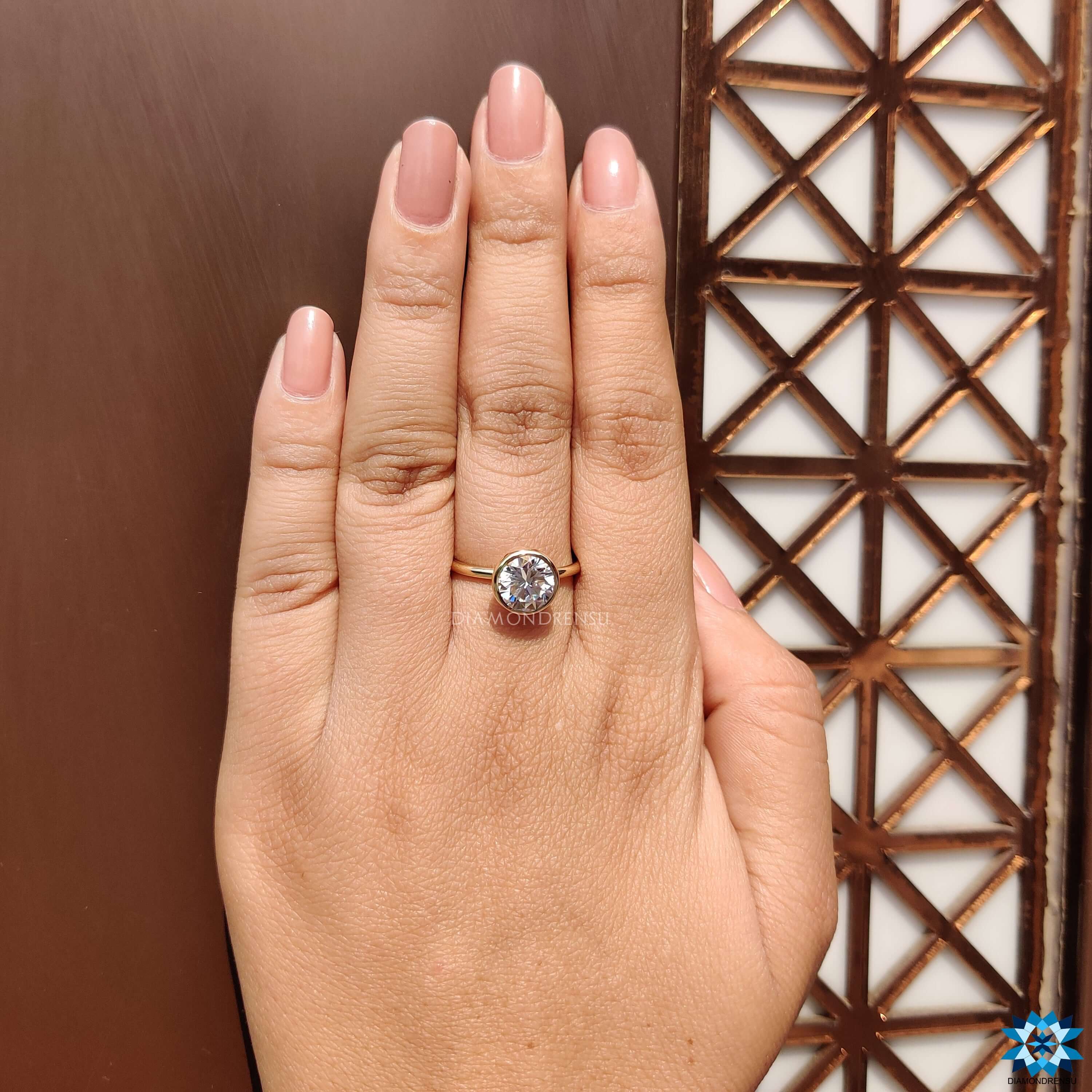 Solitaire ring with bezel mount holding a round moissanite.