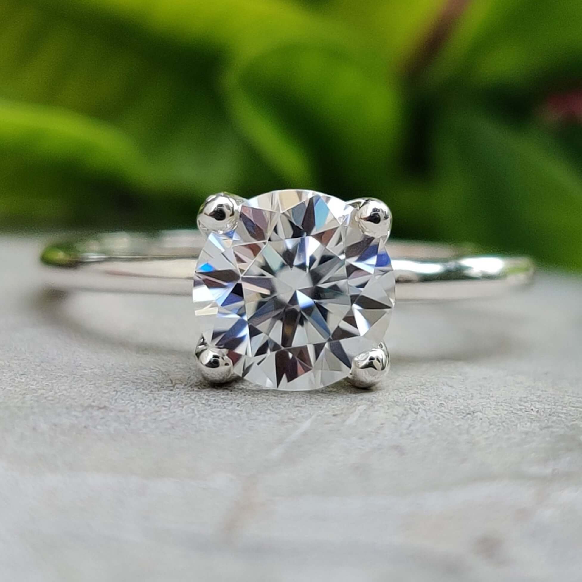 Round cut moissanite solitaire engagement ring in white gold.