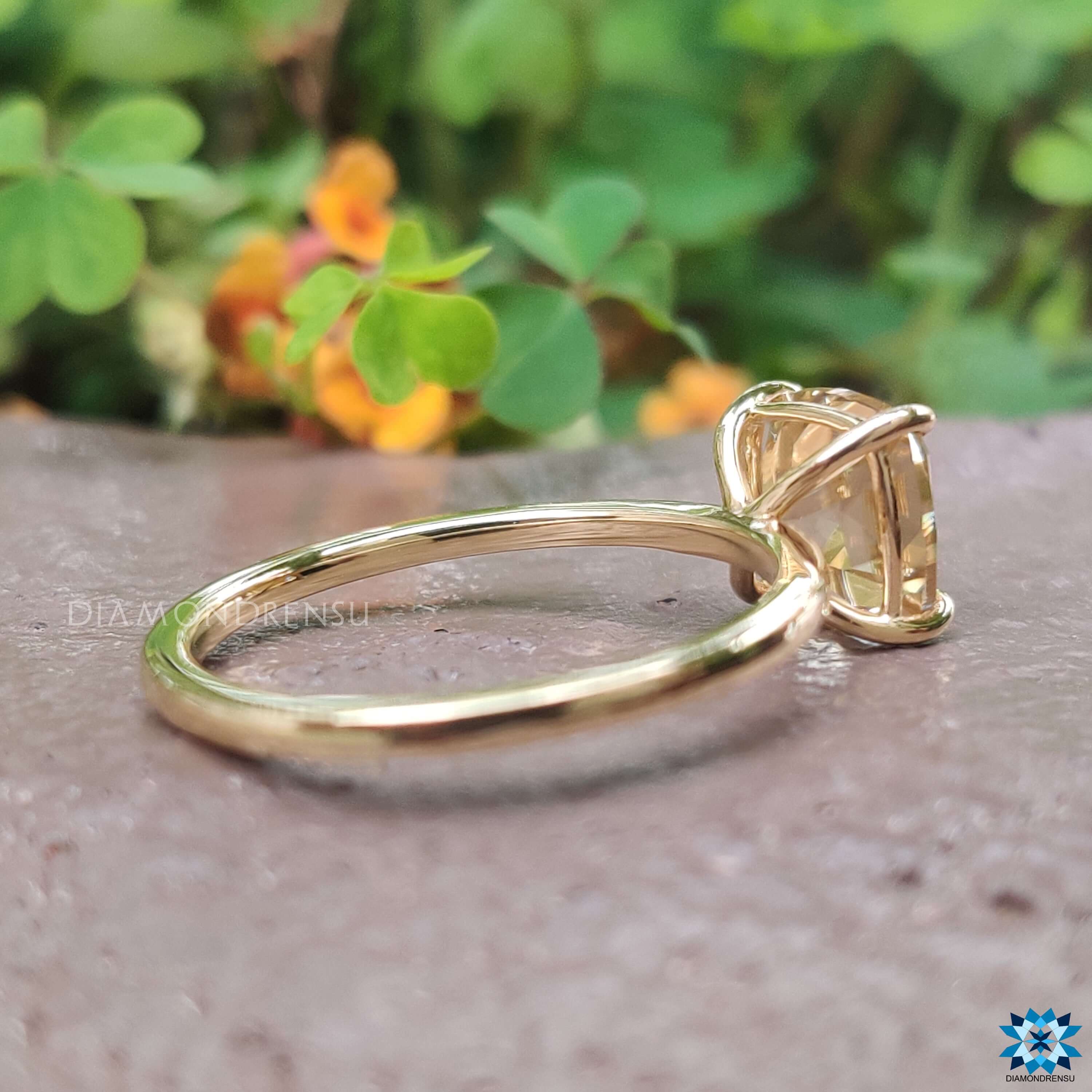 Light yellow cushion moissanite ring in four-prong setting.