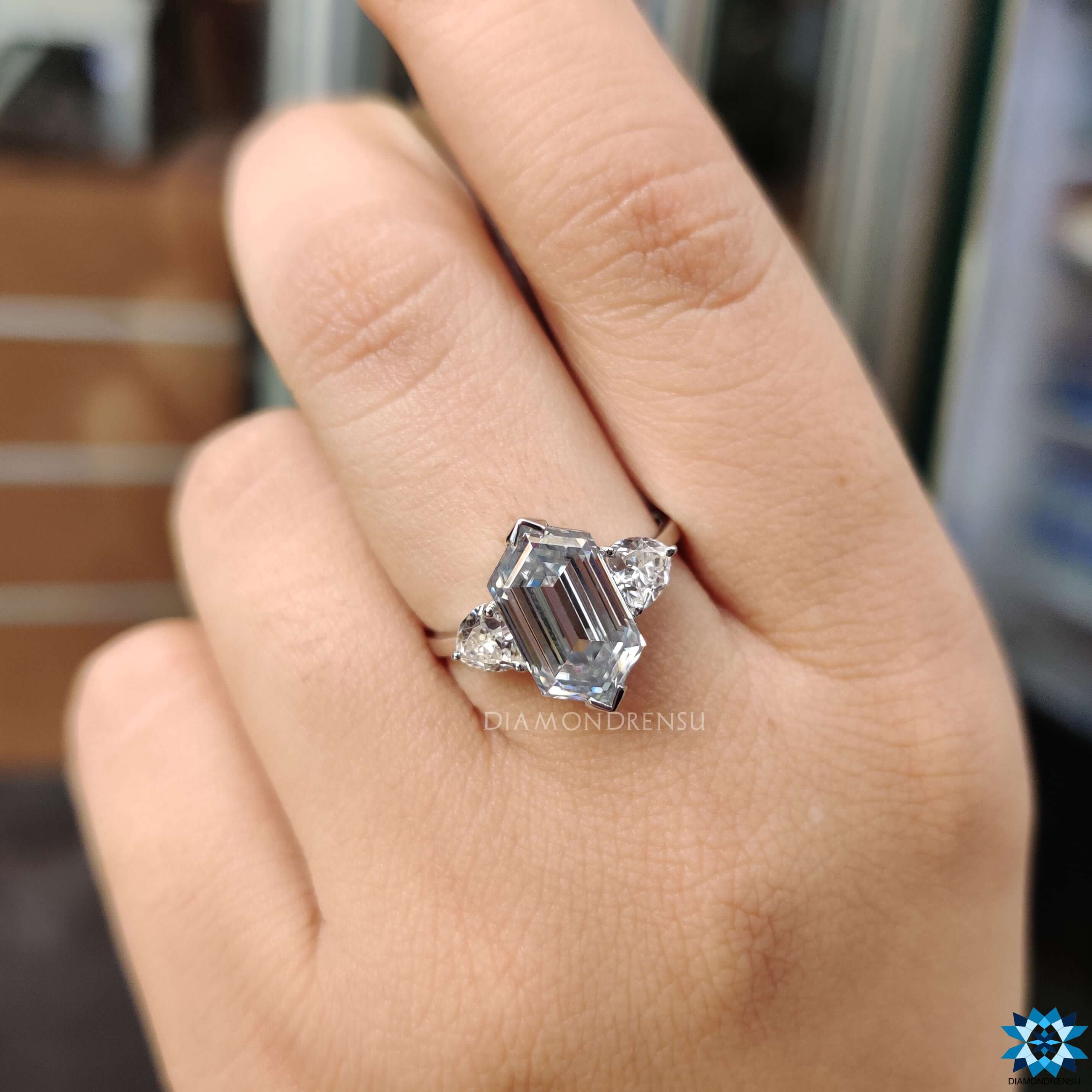 Three stone hexagon engagement ring with trillion side stones.