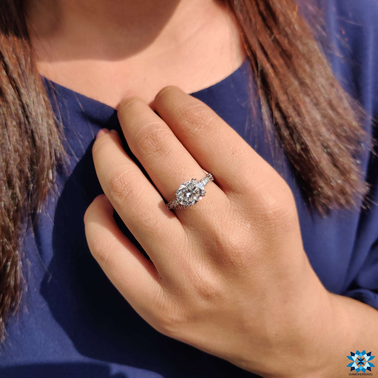 Oval cut moissanite ring set in white gold with elegant vintage styling.
