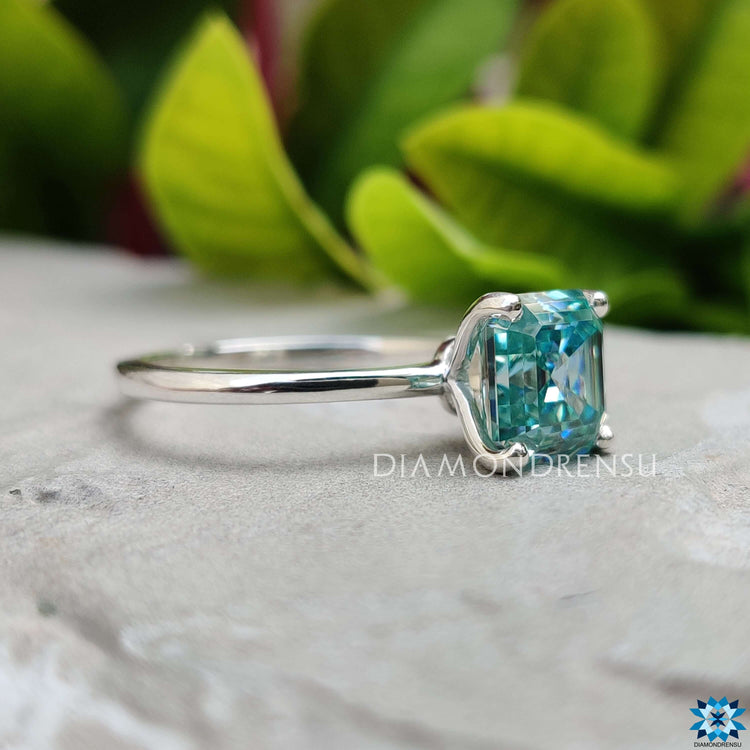 Handmade solitaire engagement ring with cyan blue moissanite.