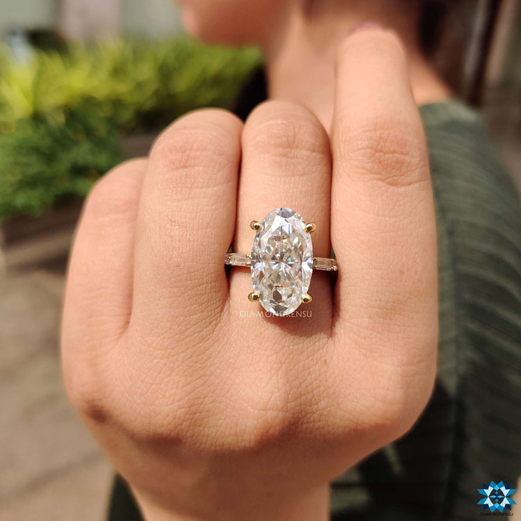 Yellow gold moval cut ring with round and baguette moissanite stones.