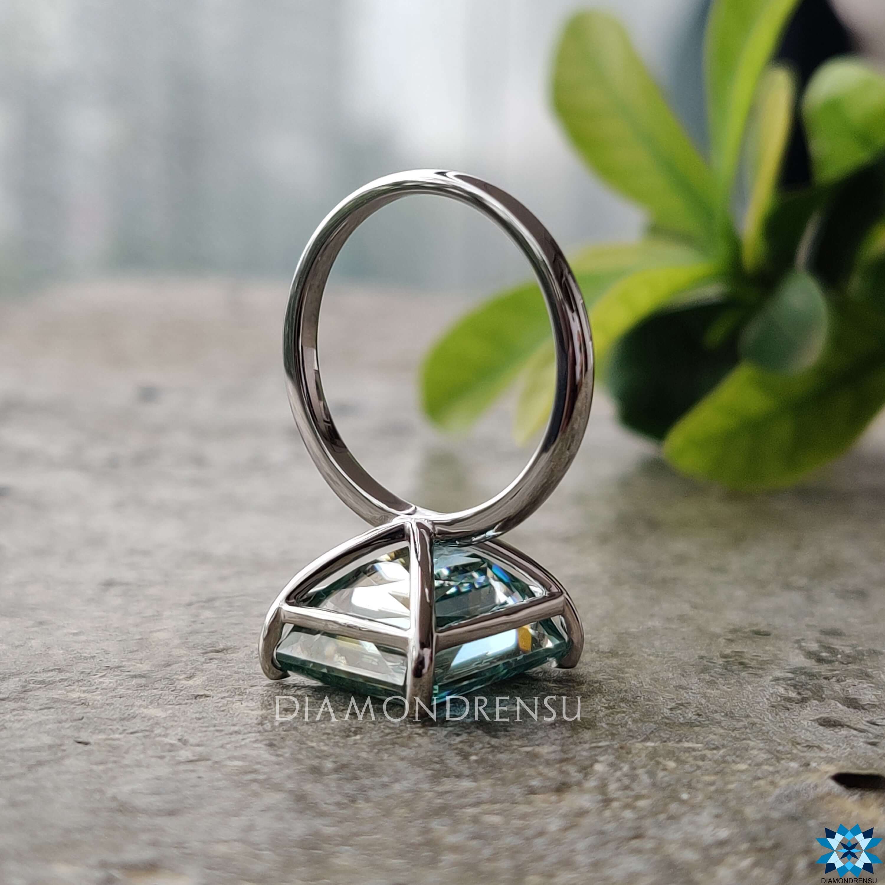 4 prong claw setting holding a vibrant cyan blue moissanite stone.