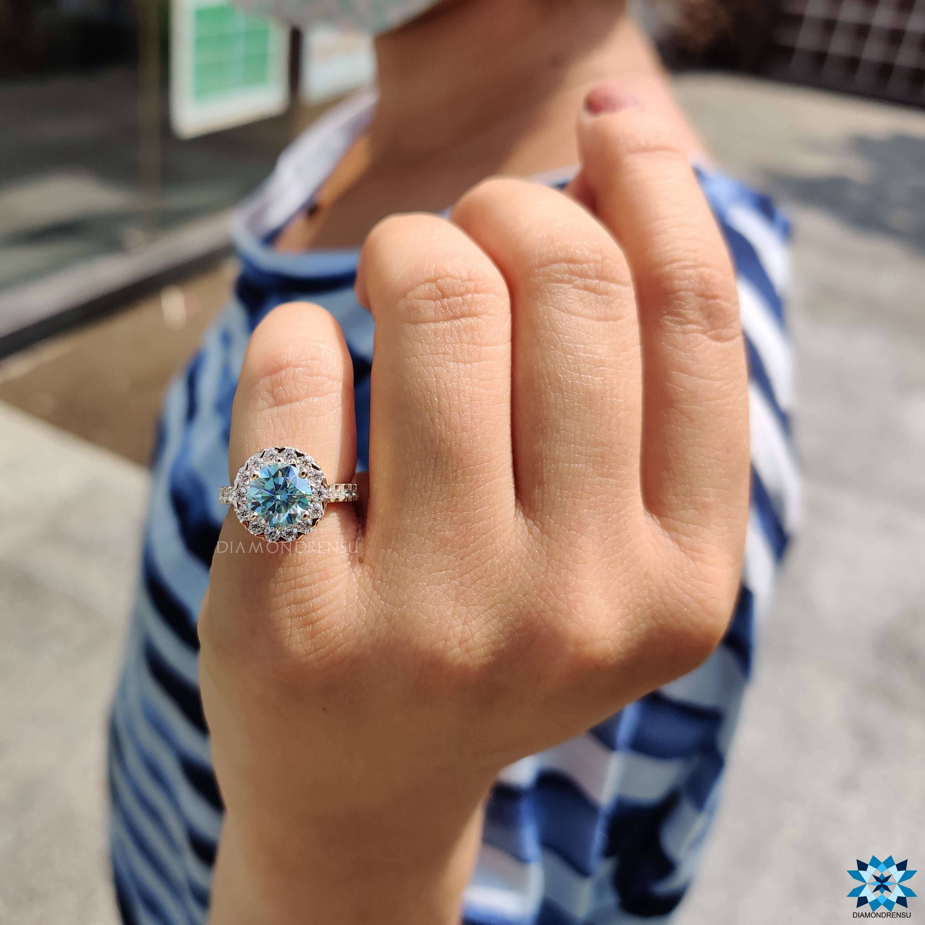 Cyan blue moissanite ring with halo setting.
