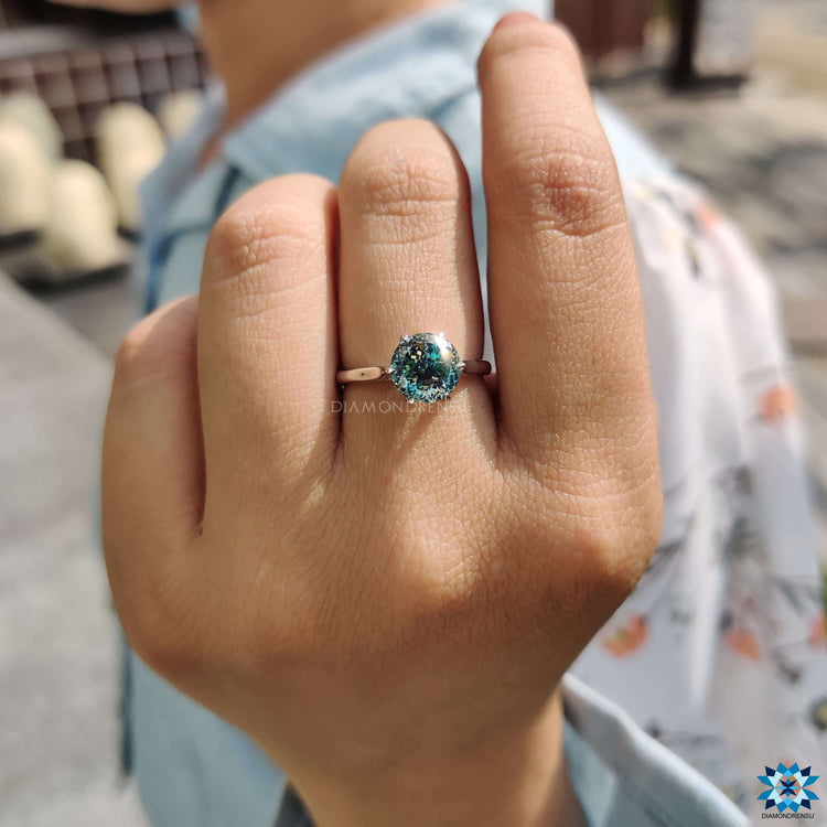 Cyan blue moissanite solitaire ring in white gold.