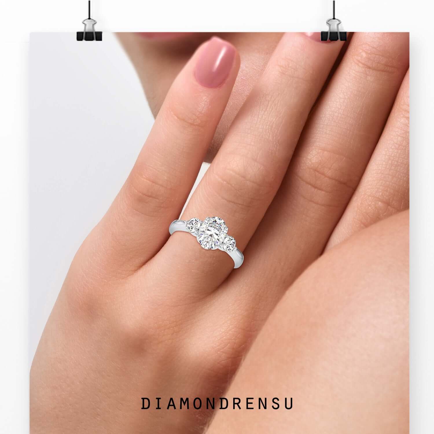 Oval diamond ring with two round cut side stones.