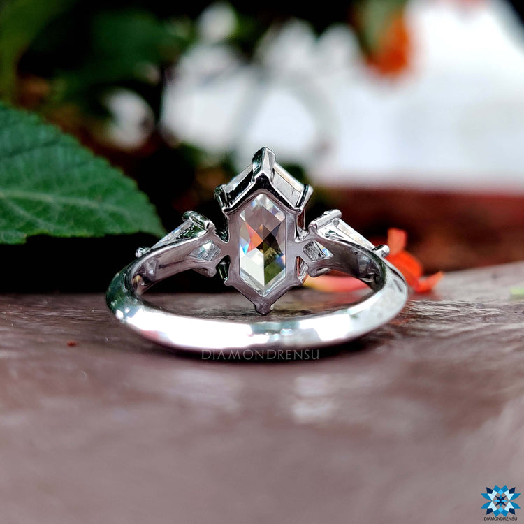 White gold moissanite ring with three stone layout and elegant v shaped prong design.