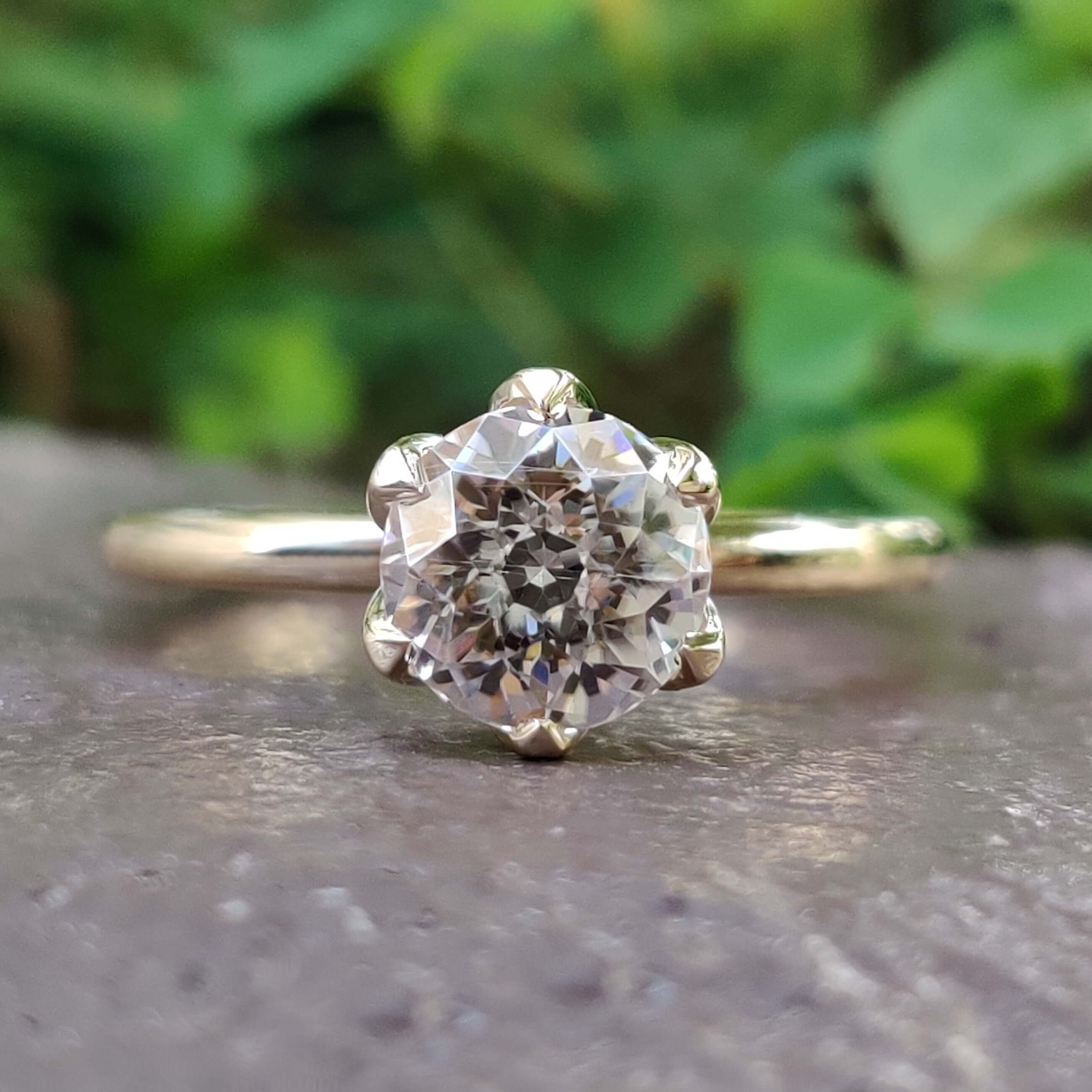 Tulip setting engagement ring with round moissanite.