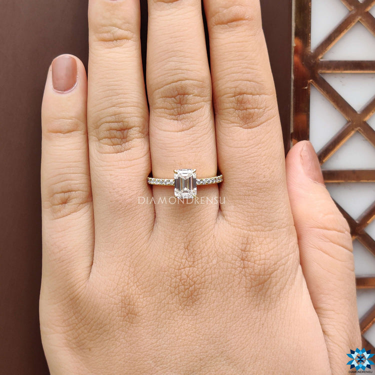 Under halo emerald moissanite ring in classic prong mount.
