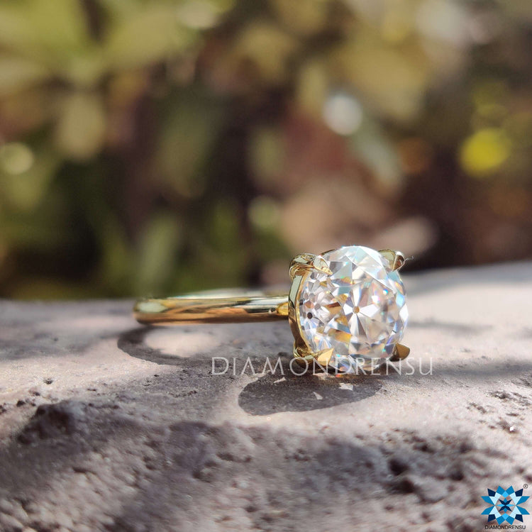 Yellow gold ring featuring round cut moissanite center stone.