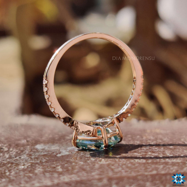 Handmade moissanite ring featuring compass prong and round side stones.