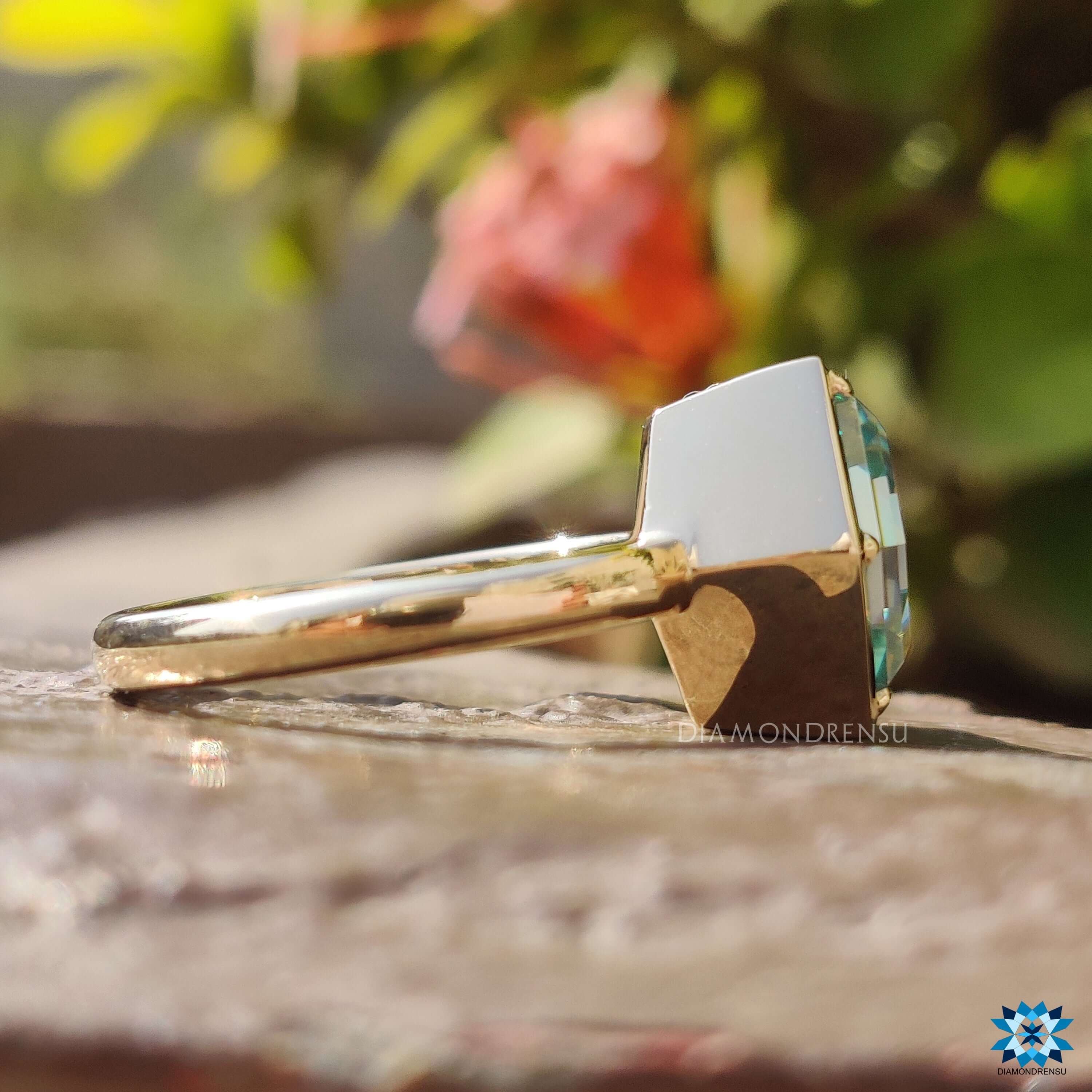 Yellow gold moissanite engagement ring with solitaire bezel design.